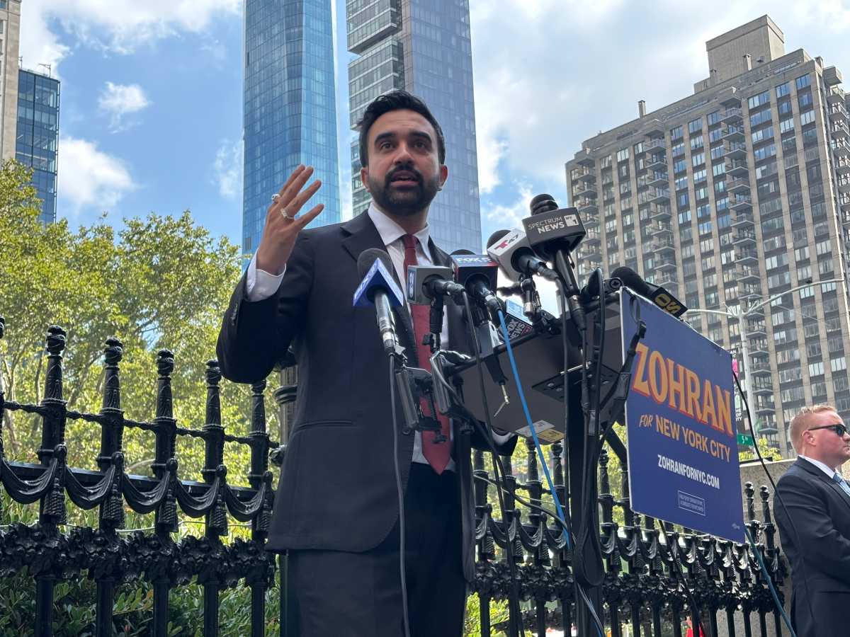 Mayoral candidate Zohran Mamdani speaking in front of microphones