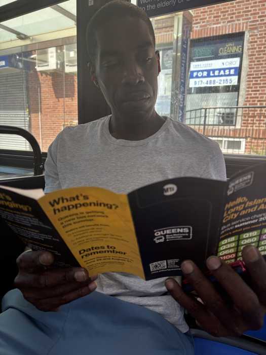 MTA got busy with second phase of Queens bus network redesign this weekend 2 man reading a brochure on a bus in Queens